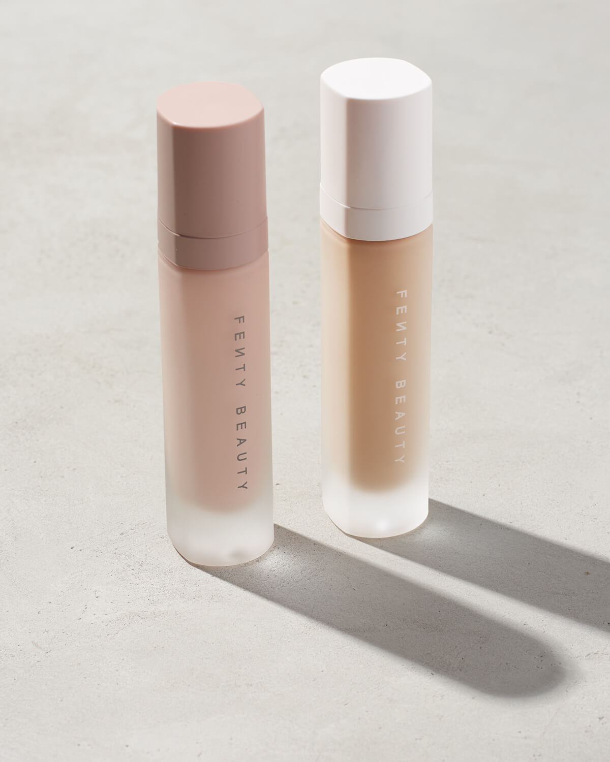 Fenty pro filter instant retouch and liquid Fenty foundation primers standing on a gray background