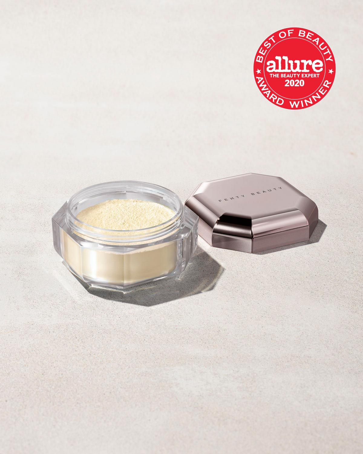 Open container of Pro Filt'r Instant Retouch Setting Powder in shade butter on a concrete background. Allure best of beauty award winner 2020 badge on the top right.