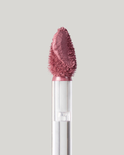 Close-up of of a Fenty Icon Velvet lipstick wand on a light background.